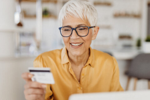 A woman looks at her credit card when budgeting.