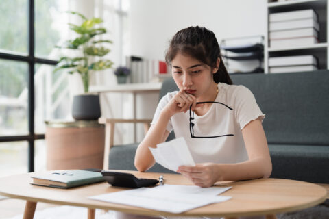 A woman sitting at a desk checking credit score.