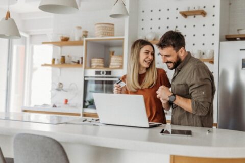 Couple in kitchen happy after checking credit scores