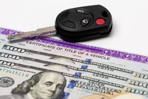 Car key, vehicle title, and 100-dollar bills, symbolizing automobile purchase, ownership, and taxes